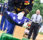 Symbolic touching of the American Flag to SPC Daniel “Lucas” Elliott's remains before being presented to his Mother.