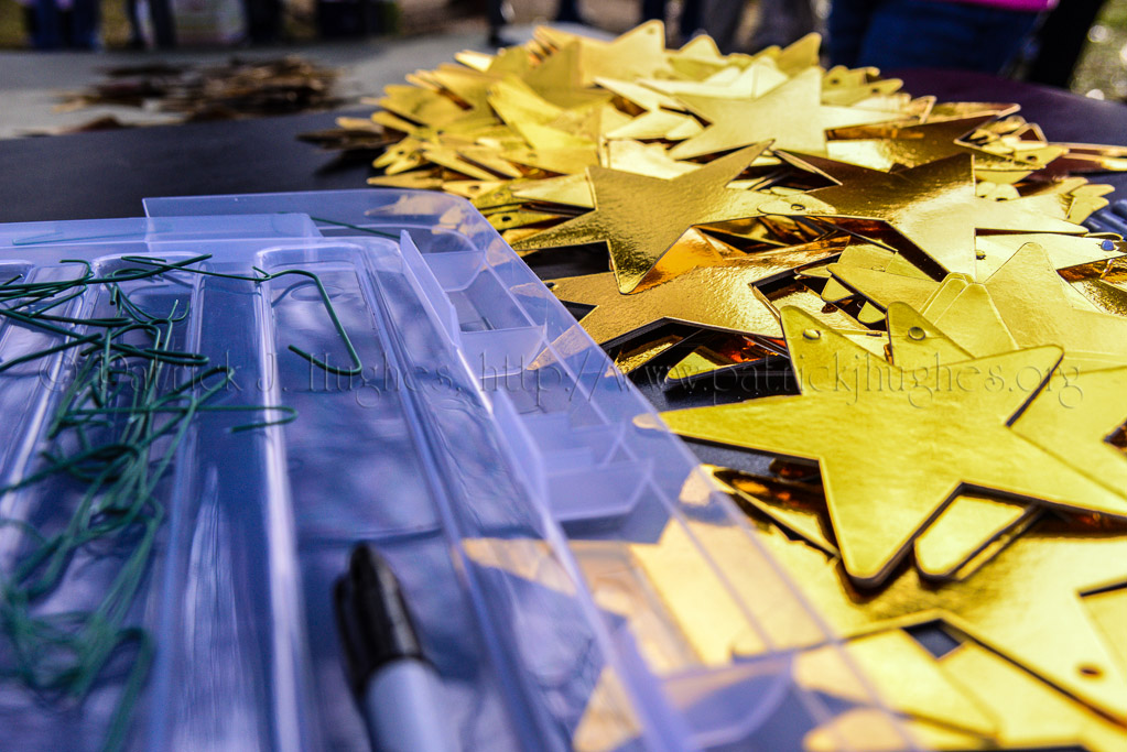 Some tables were set up with gold stars, markers and hooks to hang the personalized tree ornaments