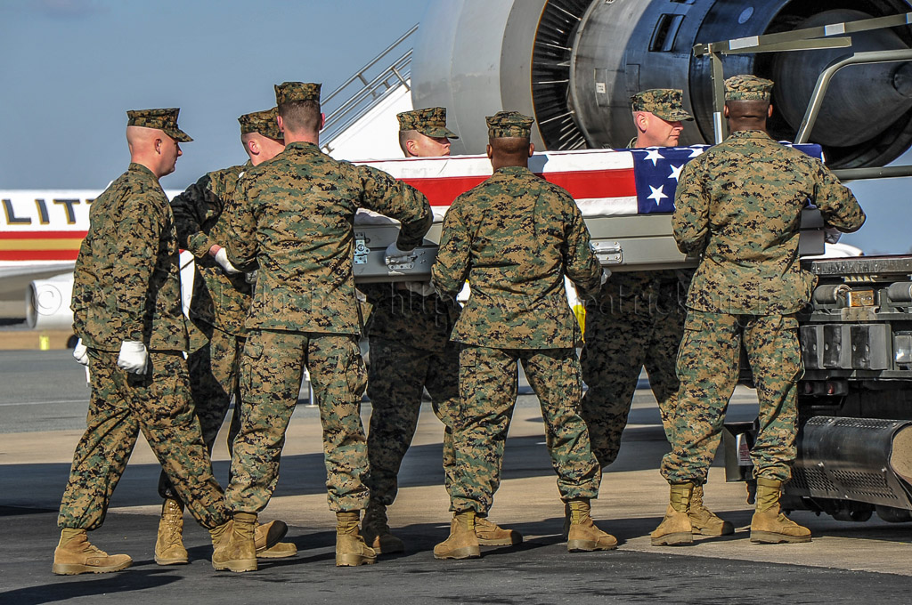 Marine carry team carries transfer case of L/Cpl Jeremy M. Kane from end of 747 K-loader to the transfer vehicle