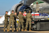 Marine carry team carries transfer case of Sgt. Daniel M. Angus from end of 747 K-loader to the transfer vehicle