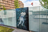 Standing alongside the glass panels, which are embedded with images and text, the silhouettes help interpret the challenges and feelings of the disabled veteran: call of duty and pride in service; trauma of injury; healing; and renewal of purpose.