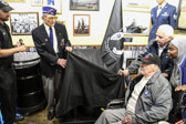 In wheel chair World War II former POW Dominick DeMidio, who was captured while parachuting with the 82nd Airborne during the invasion of Normandy helps to unveil Mission BBQ 365 N Dupont Hwy, Dover, DE POW/MIA National Chair of Honor.