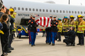 Honor our “Fallen Hero” by placing your hand over your heart as the Marine Corps Honor Guard carry Private First Class Michael Kocopy from the plane to the hearse for his final journey home.