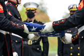 Marine Colonel Styskal watches as Body Bearers finish folding the flag