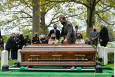 Family member Craig Emmerson places a single red rose on casket