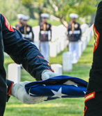 The folded flag is passed along to the awaiting officer for presentation to the family member.