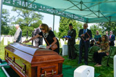 Niece Janet A. Cook places a small flag on the casket of her Uncle 1LT Justin Green Mills