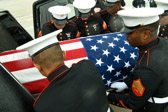 Marine Body Bearers place the casket containing the remains of Pvt. William E. Rambo into the hearse.